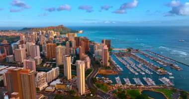 Günbatımında Waikiki 'nin yüksek kentsel manzarası. Diamond Head Krateri arka planda. Yat kulübündeki rıhtımlarda bir sürü yat var. Hava görünümü.
