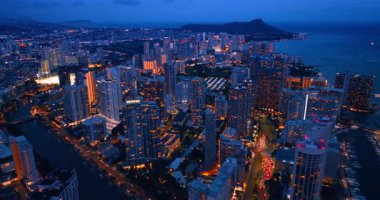 Waikiki 'nin gece manzarası. Alacakaranlıkta muhteşem aydınlatılmış şehir manzarası. Hava görünümü.