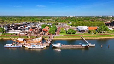Küçük modern teknelerle çevrili VOC gemisi Batavia 'nın yeniden inşası. Hollanda, Lelystad rıhtımında uçuyor. Hava görünümü.