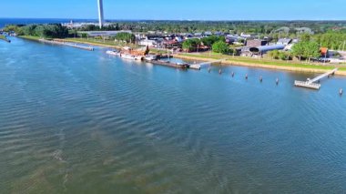 Rıhtıma yaklaşan göl manzarası üzerinde ilerliyoruz. Batavia gemisinin iskelenin yakınında yeniden inşası. Telekom kulesi arka planda. Hava perspektifi.