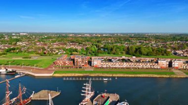 Rıhtımda duran yelkenlilerle teknelerin üstünde uçmak. Lelystad 'ın göz kamaştırıcı manzarası, Hollanda yemyeşil arka planda.