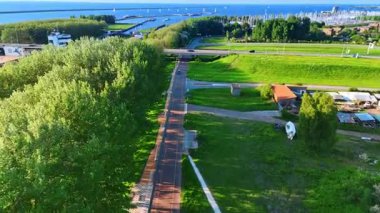 Rıhtımda yemyeşil alanlar büyüyor. Arabalar yollar ve köprüler boyunca hızlı hareket ederler. Birden fazla yatla göz kamaştırıcı marina manzarası. Lelystad, Hollanda. Hava görünümü.