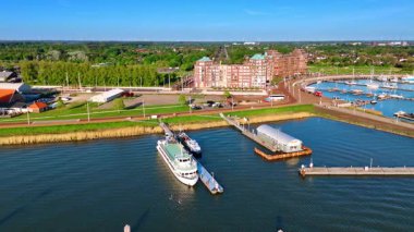 Lelystad 'ın güneşli kıyıları, Hollanda. Resimli rıhtım boyunca uçarak, tekneli bir limana yaklaşıyor..