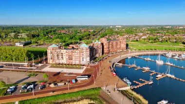 Hollanda, Lelystad 'ın rıhtımındaki güzel binalar. Güneşli bir günde İHA görüntülerinden yeşil şehrin güneşli manzarası.