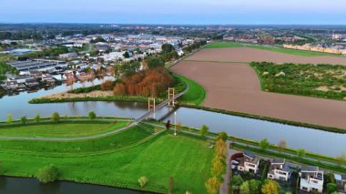 Hollanda, Lelystad 'da bir köprüye yaklaşıyoruz. Gün batımında şehrin üzerinde insansız hava aracı görüntüleri.