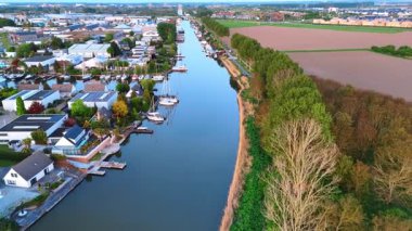 Mavi gökyüzü kanalın pürüzsüz su manzarasına yansıyor. Hollanda, Vinkeveen 'e hava perspektifi.