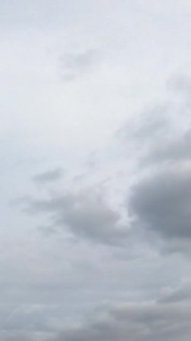 Gökyüzünde gri yağmurlu bulut manzarası. Atmosferde dramatik bulutlar yayılıyor. Düşük açı. Zaman ayarlı. Dikey video