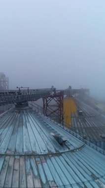 Metal tahıl asansör inşaatı. Büyük endüstriyel asansör konteynırları hava manzaralı. Dikey video