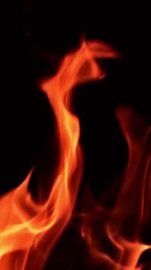 Havada alevler yükseliyor. Karanlıkta şenlik ateşi yanıyor. Kapatın. Dikey video