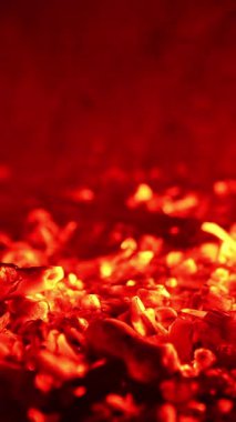 Parlayan kömür parçaları çok güzel parlıyor. Küçük ateş alevleri tekrar patlak verdi. Kapatın. Dikey video