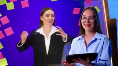 Beyin fırtınası ekibi. İki profesyonel fikir üretimi için renkli yapışkan notlar ve dijital araçlarla beyin fırtınası yapıyorlar..