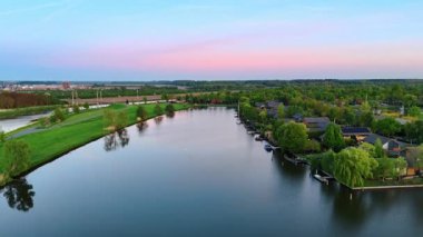 Suyu olan huzurlu bir Hollanda manzarası. Hollanda 'da günbatımında renkli bir gökyüzü altında yemyeşil bir su yolu manzarası..