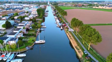 Tekneli kanal manzaralı, NL. Hollanda 'nın kentsel bölgelerinin yakınında gün ışığında açık bir gökyüzü altında tekne ve ağaçlarla dolu sessiz bir kanal..
