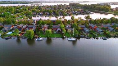 Hollanda rıhtımındaki muhteşem evler. Hollanda 'da deniz kenarı manzaralı evler, gün batımında yemyeşil ve huzurlu yansımalarla çevrili..