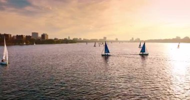 Gün batımında nehirde yüzen tekneler. Boston, Massachusetts, ABD 'deki Charles Nehri üzerindeki su sporları.