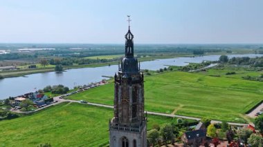 Hollanda 'nın Utrecht ilindeki Rhenen şehrindeki Cunera Kilisesi' nin saat kulesinin tepesinde. Resimli şehir manzarası güneşli bir günde arka planda.