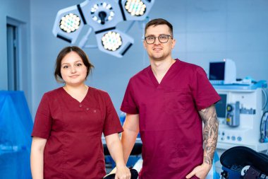 Ameliyathanede cerrahlar var. İki tıp uzmanı modern bir ameliyathanede birlikte poz veriyorlar. Yeni bir prosedür için hazırlar..