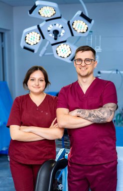 Modern bir klinikteki klinikçiler. İki sağlık çalışanı güler ve güpegündüz iyi donanımlı bir sağlık kliniğinde rahatça poz verir..