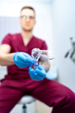 Hastalara yardım etmeye hazırım. Önlüklü bir sağlık görevlisi, klinikte hasta danışmanlığına hazır bir tıbbi araçla oturur..