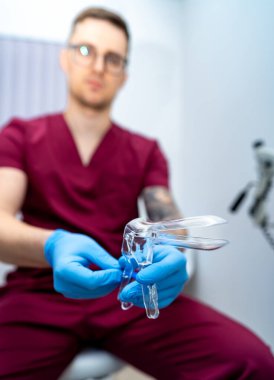 Sağlık uzmanları sınava hazırlanıyor. Önlüklü bir sağlık görevlisi, klinik bir ortamda hasta bakımı ve güvenliğine odaklanan bir enstrüman hazırlıyor..