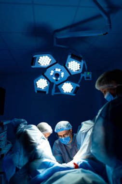 Cerrahlar hayati ameliyatlar yapar. Tıbbi ekip, hasta bakımına odaklanmış iyi donanımlı bir ameliyathanede acil bir cerrahi müdahale gerçekleştiriyor..