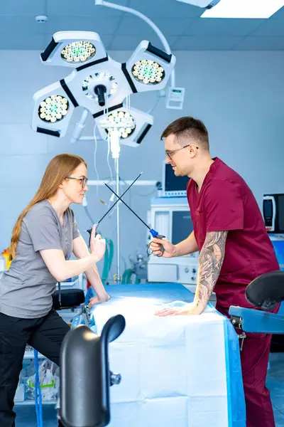 Bir tartışmada doktorlar. Ameliyat odasındaki cerrahi aletler üzerine hararetli bir tartışma içinde olan önlüklü iki tıp uzmanı görülüyor..