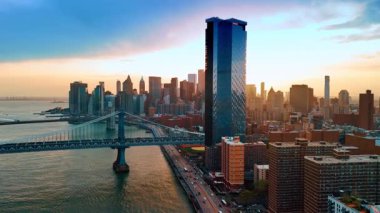 Gün batımında New York 'un muhteşem manzarası. Manhattan Köprüsü ve Doğu Nehri. İnsansız hava aracı görüntüleri.