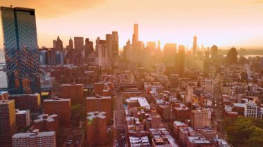 Güzel altın ışık Manhattan, New York manzarasını kaplıyor. Şehir merkezindeki gökdelenlerin arkasından güneş parlıyor. Hava perspektifi.