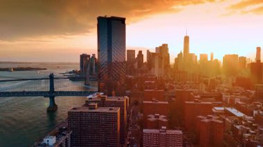 Manhattan Köprüsü ve Doğu Nehri yakınlarındaki cam gökdelenine yaklaşıyoruz. New York 'ta altın saat. Hava perspektifi.