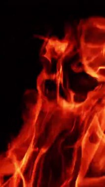 Geceleri alev alev yanan diller. Karanlığın içinde rüzgarda sallanan izole bir ateş. Dikey video