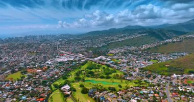 Güneşli bir günde yüksek nüfuslu bir şehir manzarasının manzarası. Modern Honolulu Panoraması, Hawaii, ABD. Şehrin üstündeki bulutlar kabarık..