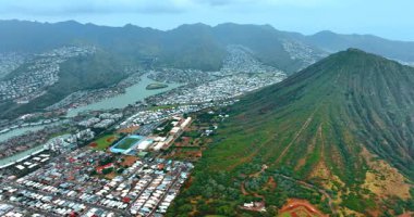 Honolulu, Hawaii, ABD 'deki dağların arasındaki vadide yoğun nüfuslu bir bölge. Diamond Head Krateri 'nin yeşil yamaçlarına bakın. Hava perspektifi.