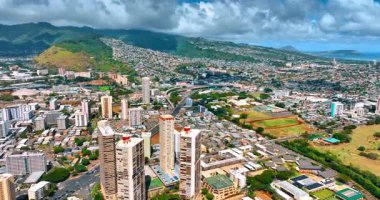 Gündüz vakti modern Honolulu, Hawaii, ABD. Arkaplanda tepeleri kaplayan dramatik bulutlar. Hava perspektifi.