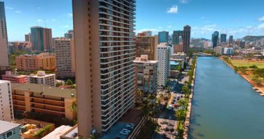 Waikiki 'yi ayıran Ala Wai Kanalı' nın rıhtımında bulunan yüksek katlı bir eve yaklaşıyoruz. Şehir manzaralı Honolulu şehir merkezi mimarisi güneşli bir günde İHA 'dan.