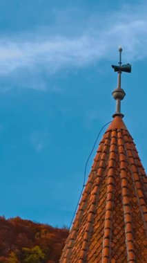 Sivri çatısında kırmızı kiremit olan kule. Romanya 'daki Bran şatosunun manzarası. Renkli doğa arka planda. Dikey video