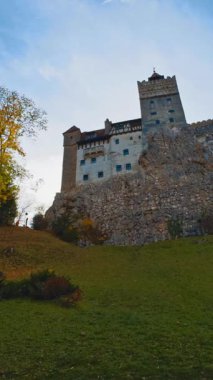 Tepenin tepesindeki güzel ortaçağ şatosunun manzarası. Rumen şatosu Bran, Kont Drakula 'nın sonbahar sezonunda. Düşük açı. Dikey video