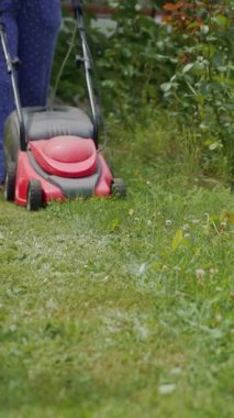 Bahçede çim biçiyorum. Açık hava ev işleri dikey video