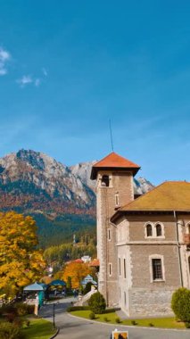 Resimli manzarada yer alan eski moda evin hoş bir manzarası. Dağlarda muhteşem bir sonbahar güneşli günü. Dikey video