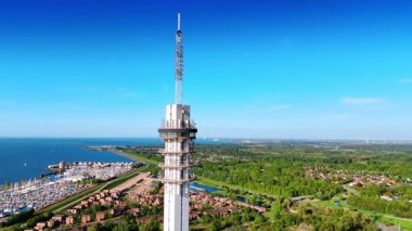 Hollanda, Lelystad 'daki telekom kulesinin tepesinde. Yeşil şehir manzarasını ve yat kulübünü gösteriyor. Hava görünümü.