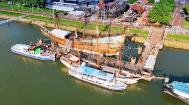 Tekneler ve gemilerle rıhtıma yakın uçuyorlar. Lelystad, Hollanda 'daki Batavialand Müzesi. Güneşli bir günde yeşil şehrin hava manzarası.
