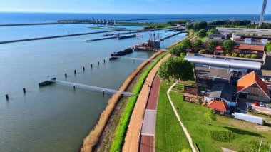 Markermeer Gölü 'nün Lakefront' u ve üzerinde barajlar var. Hollanda, Lelystad 'daki Batavialand Müzesi' ndeki Batavia gemisinin yeniden inşasına yaklaşan insansız hava aracı görüntüleri..