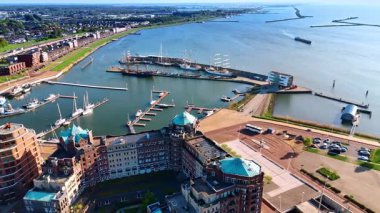 Hollanda 'nın Lelystad limanı yakınlarındaki güzel tasarım binaları. Markermeer Gölü 'nün su manzarası ve yeşil şehir manzarası üzerine hava perspektifi.