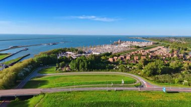 Hollanda, Lelystad 'daki büyük yat kulübüne yaklaşan yeşillik üzerinde görüntüler. Arkaplanda barajlar olan Markermeer Gölü 'nün engin suları..