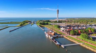 Hollanda, Lelystad 'daki Batavialand Tarihi Müzesi' nde 17. yüzyıldan kalma gemi yeniden yapılandırması. Yeşil şehir, telekom kulesi ve hendekler üzerine hava perspektifi.