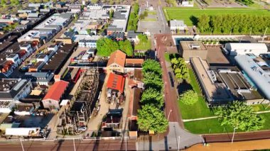 Hollanda, Lelystad 'daki Batavialand iskelesi ve müzesi üzerinde uçuyor. 17. yüzyıl gemisinin yeniden inşası Batavia ve diğer tekneler rıhtımda duruyor..