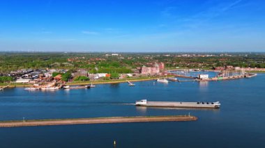Feribot hendek boyunca su kenarında hareket ediyor. Hollanda, Lelystad 'ın güneşli manzarası. Hava görünümü.