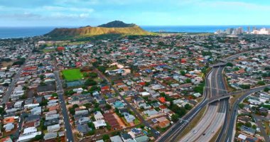 Yoğun inşa edilmiş caddeleri olan bir yerleşim yeri. Geniş şeritli otobandan geçen şehir manzarası. İHA görüntüleri Diamond Head Krateri 'ne yaklaşıyor. Honolulu, Hawaii, ABD.