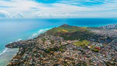 Yeşil vadide birden fazla ev inşa edilir. Diamond Head Krateri ve arka planda yüksek katlı ufuk çizgisi. Honolulu, Hawaii, ABD 'de hava perspektifi.