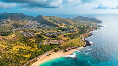 Okyanus karayla buluşuyor. Sahildeki çıplak kayalar dalgalarla kıvrılmış. Oahu kıyısı, Hawaii, ABD. Hava görünümü.