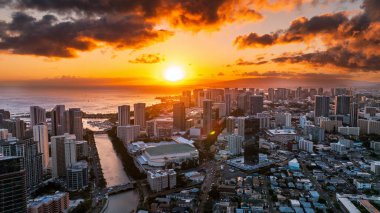 Pasifik Okyanusu 'nun su manzarası üzerinde inanılmaz turuncu güneş çemberi. Akşam üstü Honolulu şehir üzerinde insansız hava aracı uçuşu.